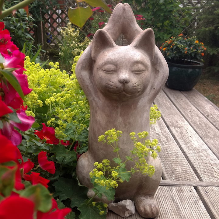 Steingut Yoga-Katze im Blumenbeet